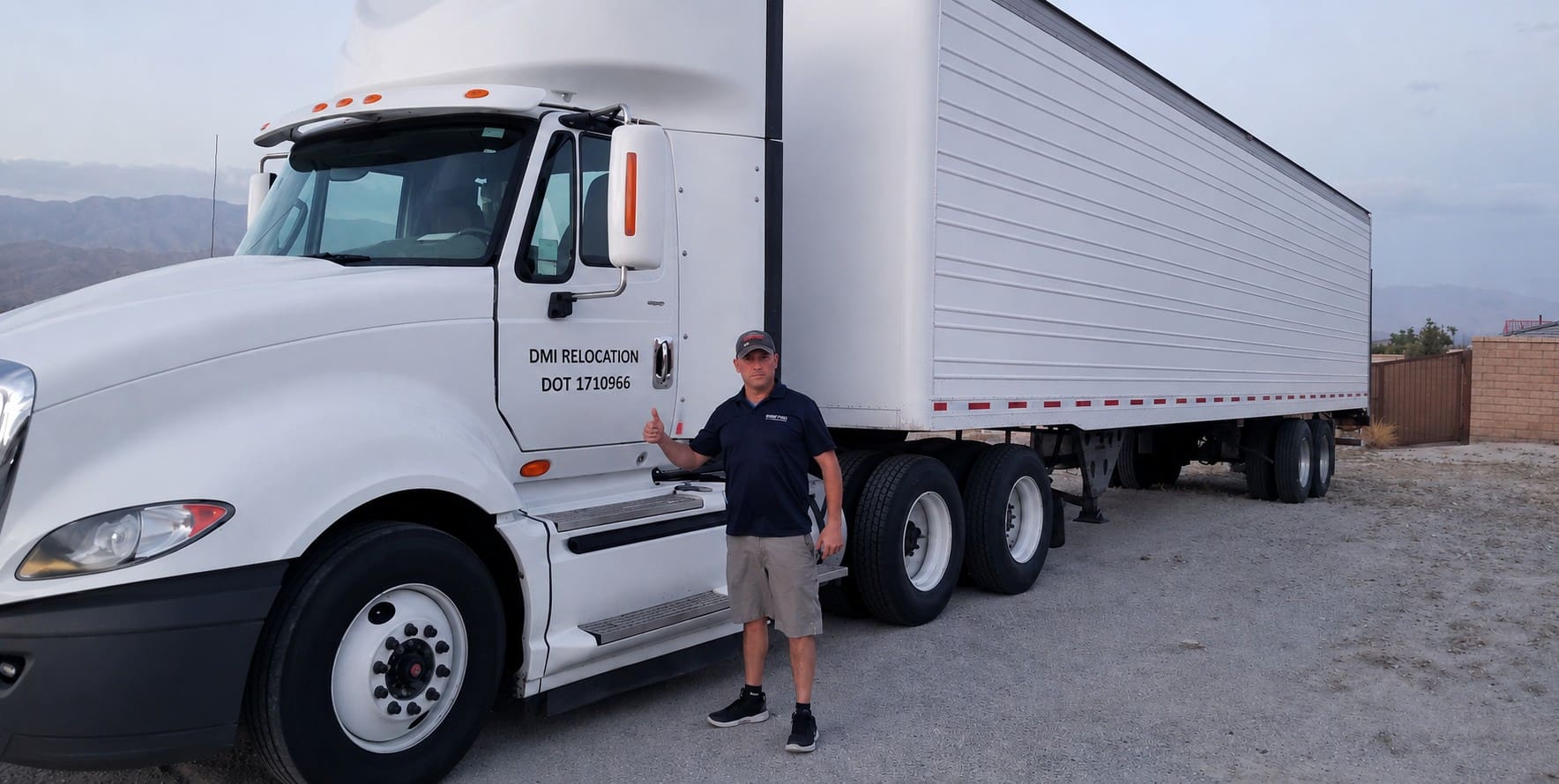 Man standing next to white semi-truck