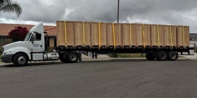 White semi flatbed truck hauling wooden crates